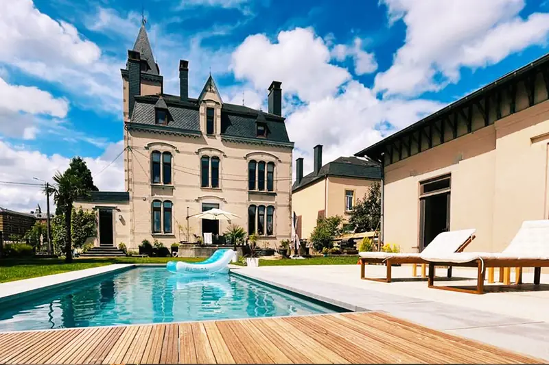 Heated pool with wooden deck in front of the villa